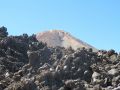Zza głazów wyłania się szczyt del Teide.